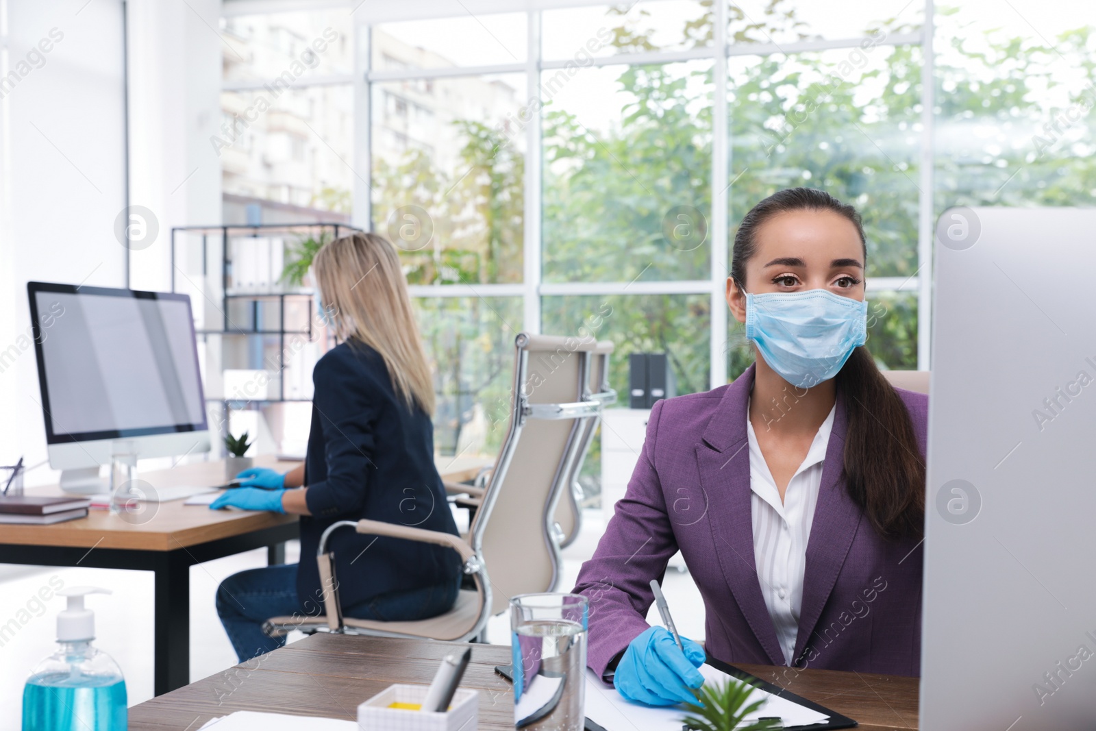 Photo of Office employees in masks and gloves at workplace