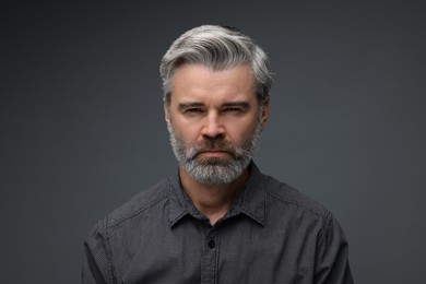 Photo of Personality concept. Portrait of emotional man on dark grey background