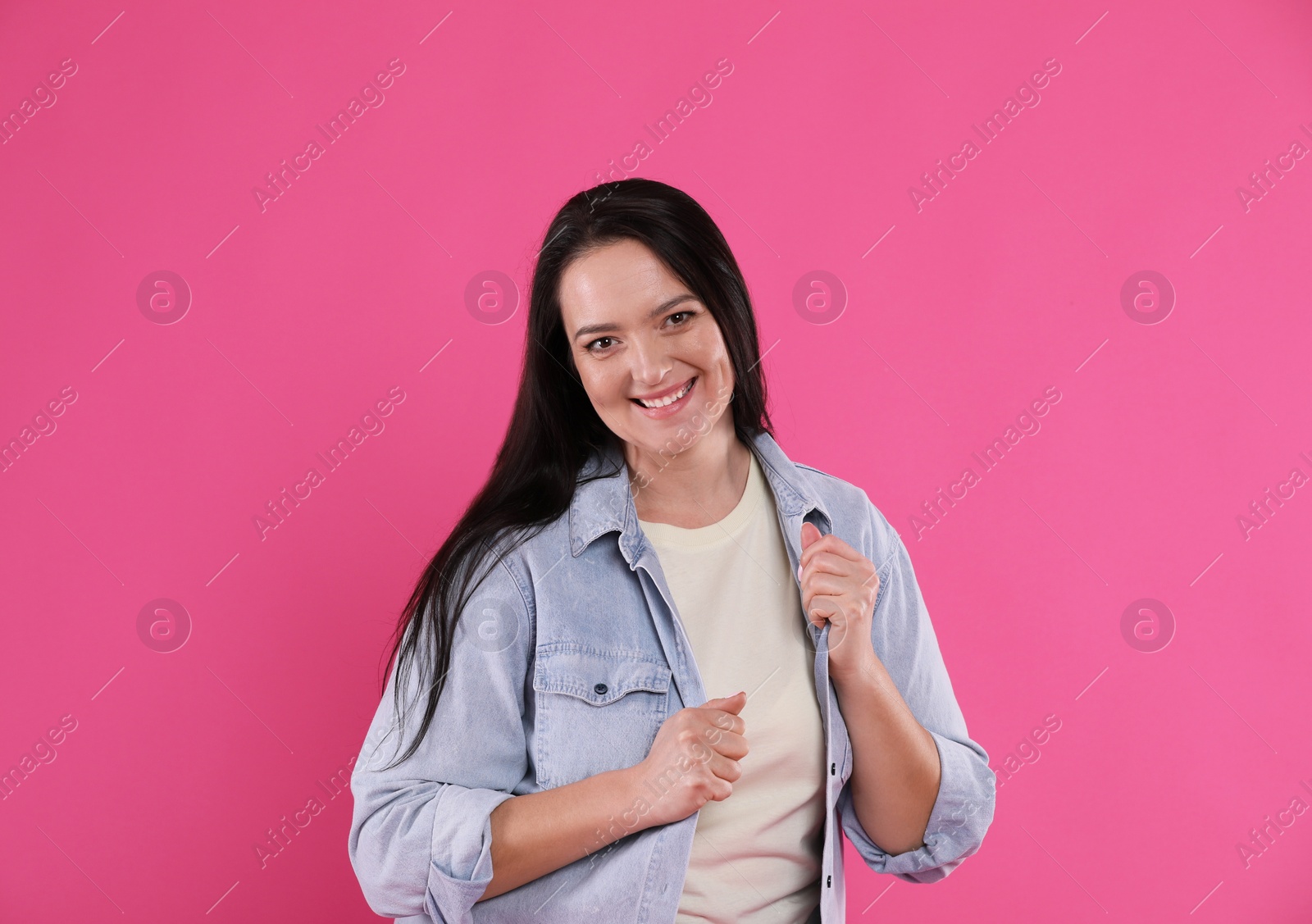 Photo of Beautiful overweight woman with charming smile on pink background