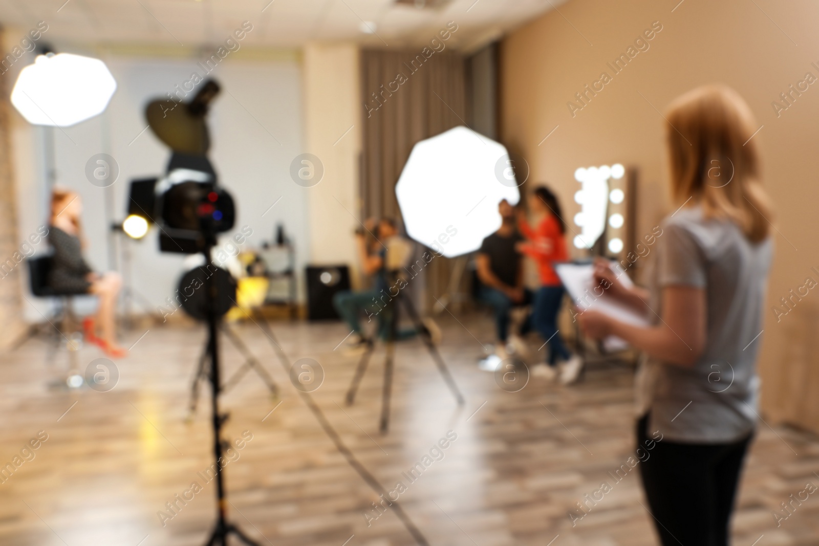 Photo of Blurred photo studio with professional equipment and team of workers