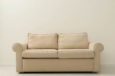 Photo of Comfortable sofa near beige wall in living room interior