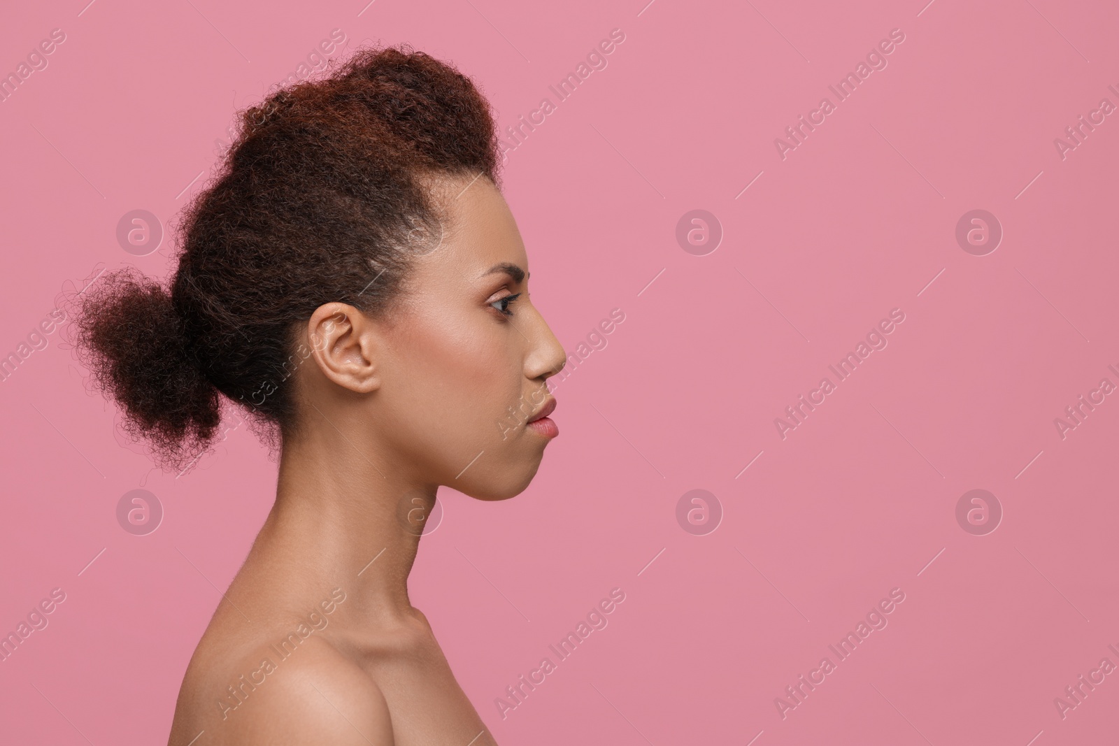 Photo of Beautiful young woman with glamorous makeup on pink background. Space for text