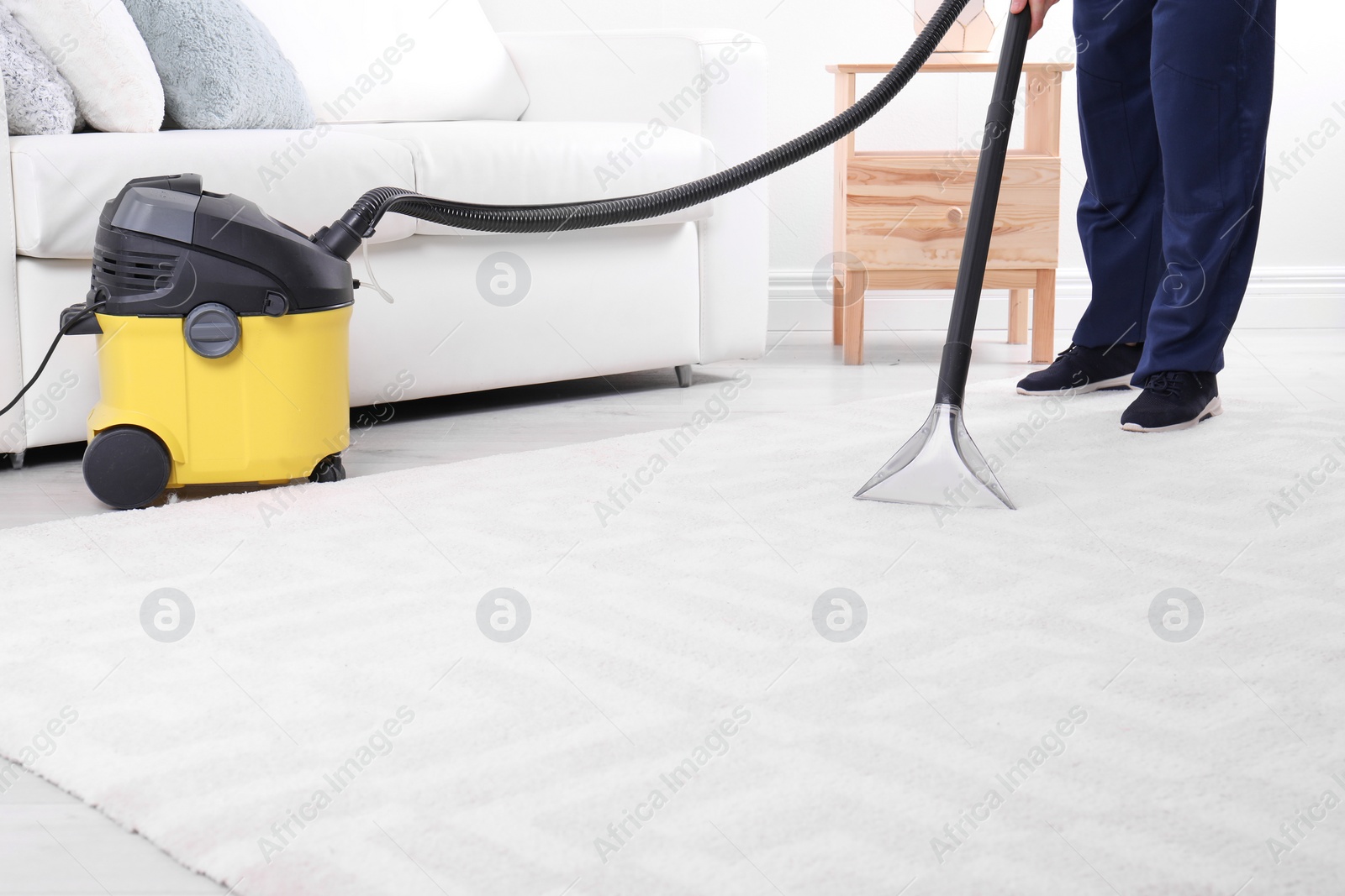 Photo of Man cleaning carpet with vacuum cleaner, closeup. Space for text