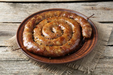 Plate with tasty homemade sausages on wooden table