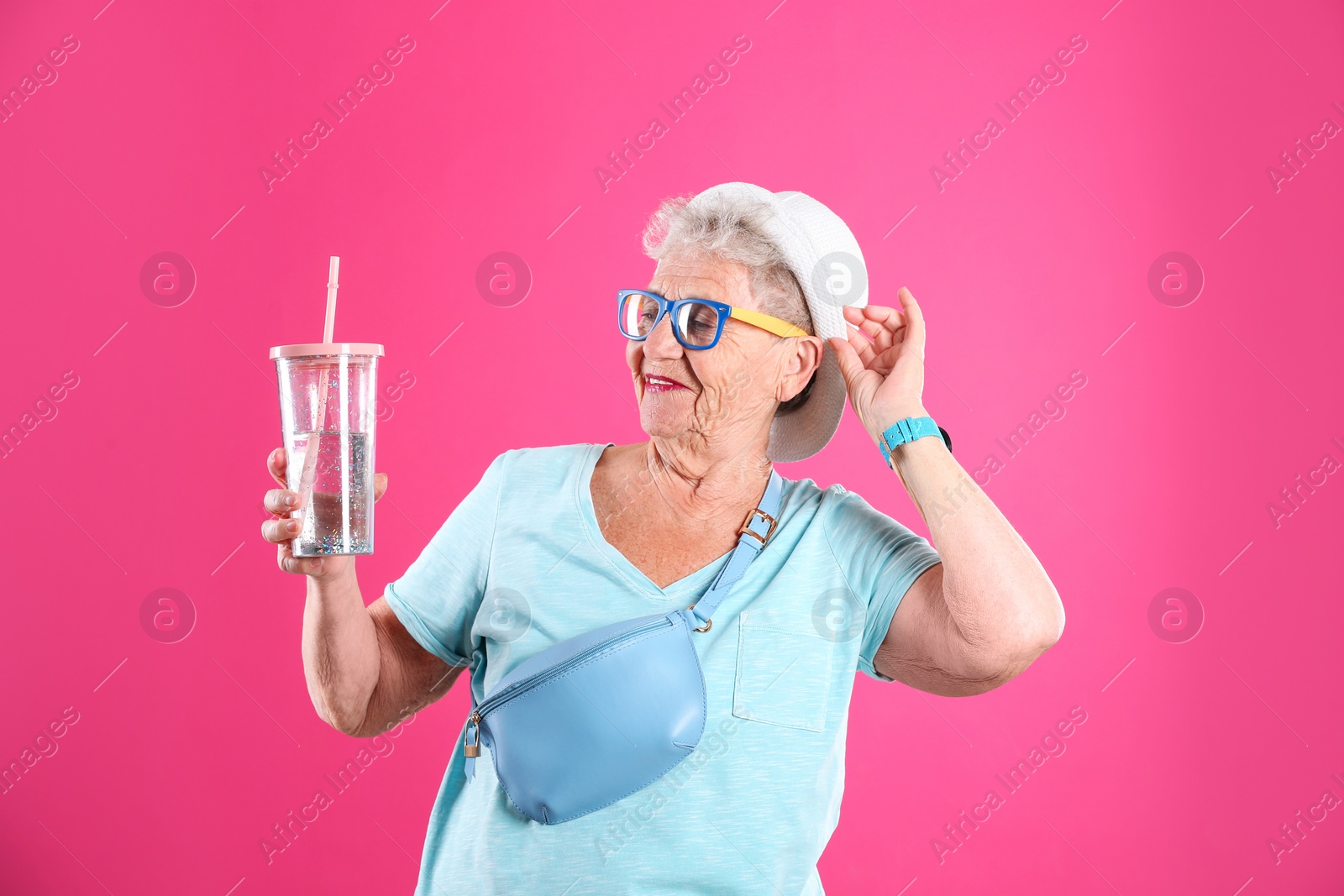 Photo of Portrait of cool grandmother with drink on color background