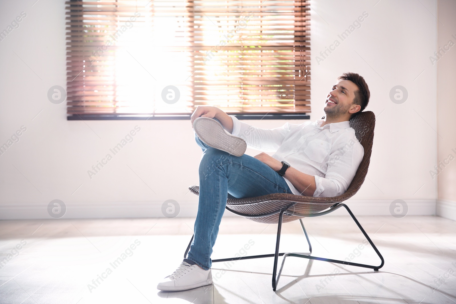 Photo of Young man relaxing near window at home. Space for text