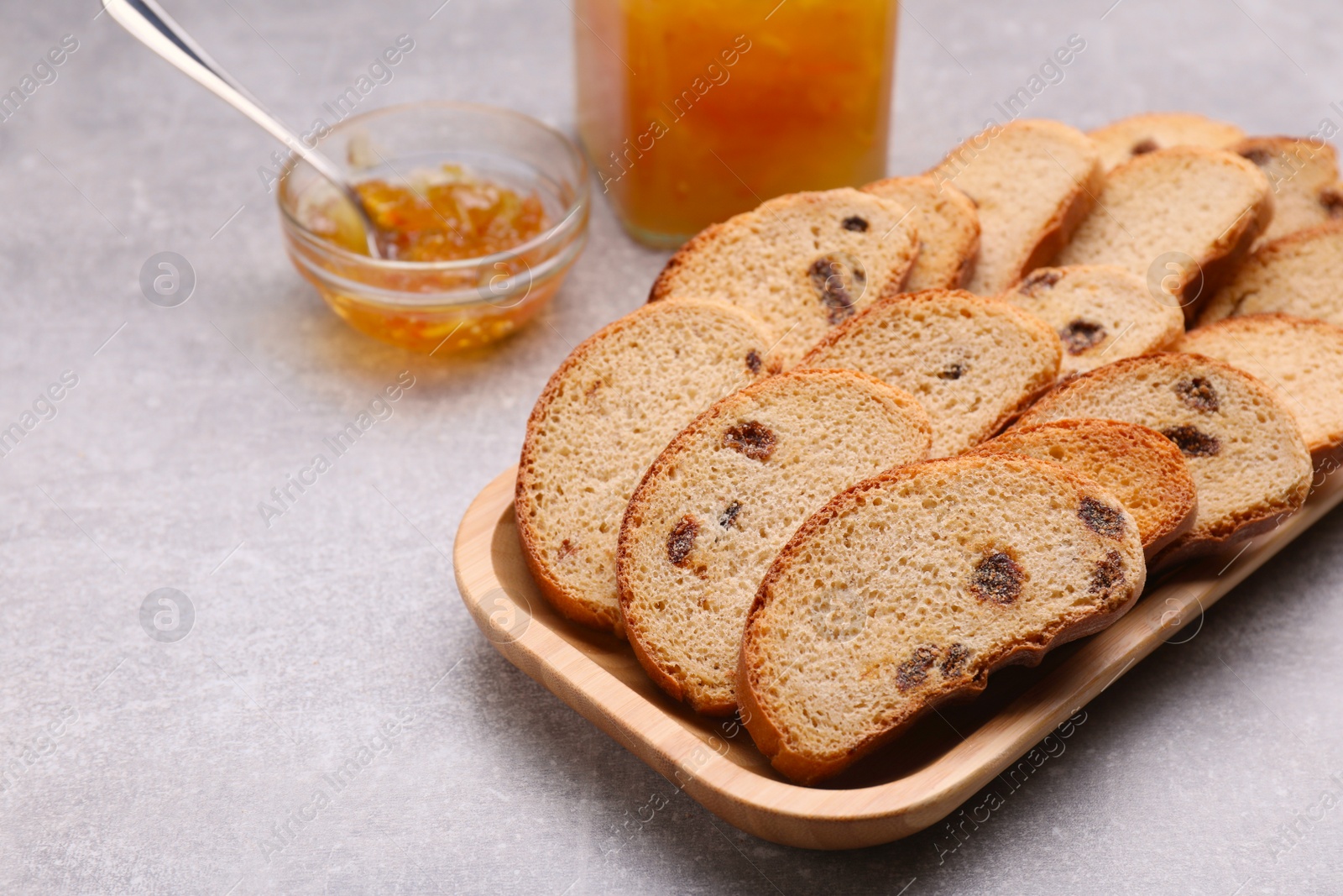 Photo of Sweet hard chuck crackers with raisins and jam on light grey table