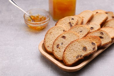 Sweet hard chuck crackers with raisins and jam on light grey table