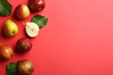 Photo of Ripe juicy pears on red background, flat lay. Space for text