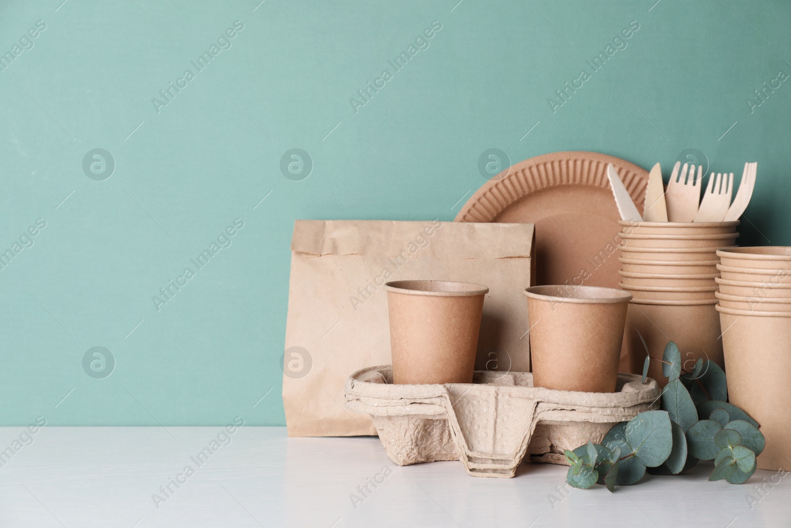 Photo of Set of disposable eco friendly dishware on white table. Space for text