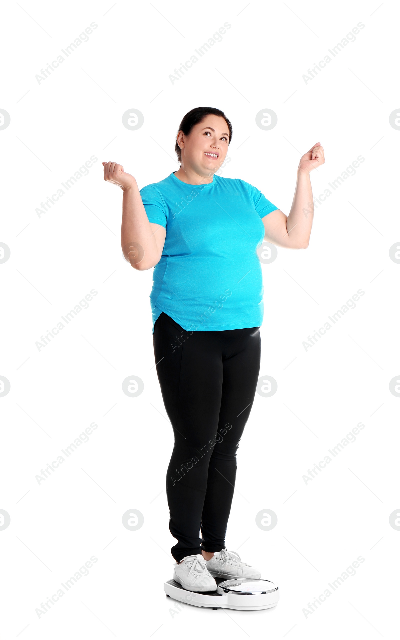 Photo of Overweight woman in sportswear using scales on white background