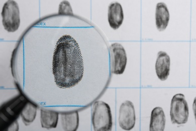 Magnifying glass and criminal fingerprint card, top view