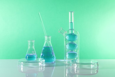 Photo of Laboratory analysis. Different glassware on table against green background