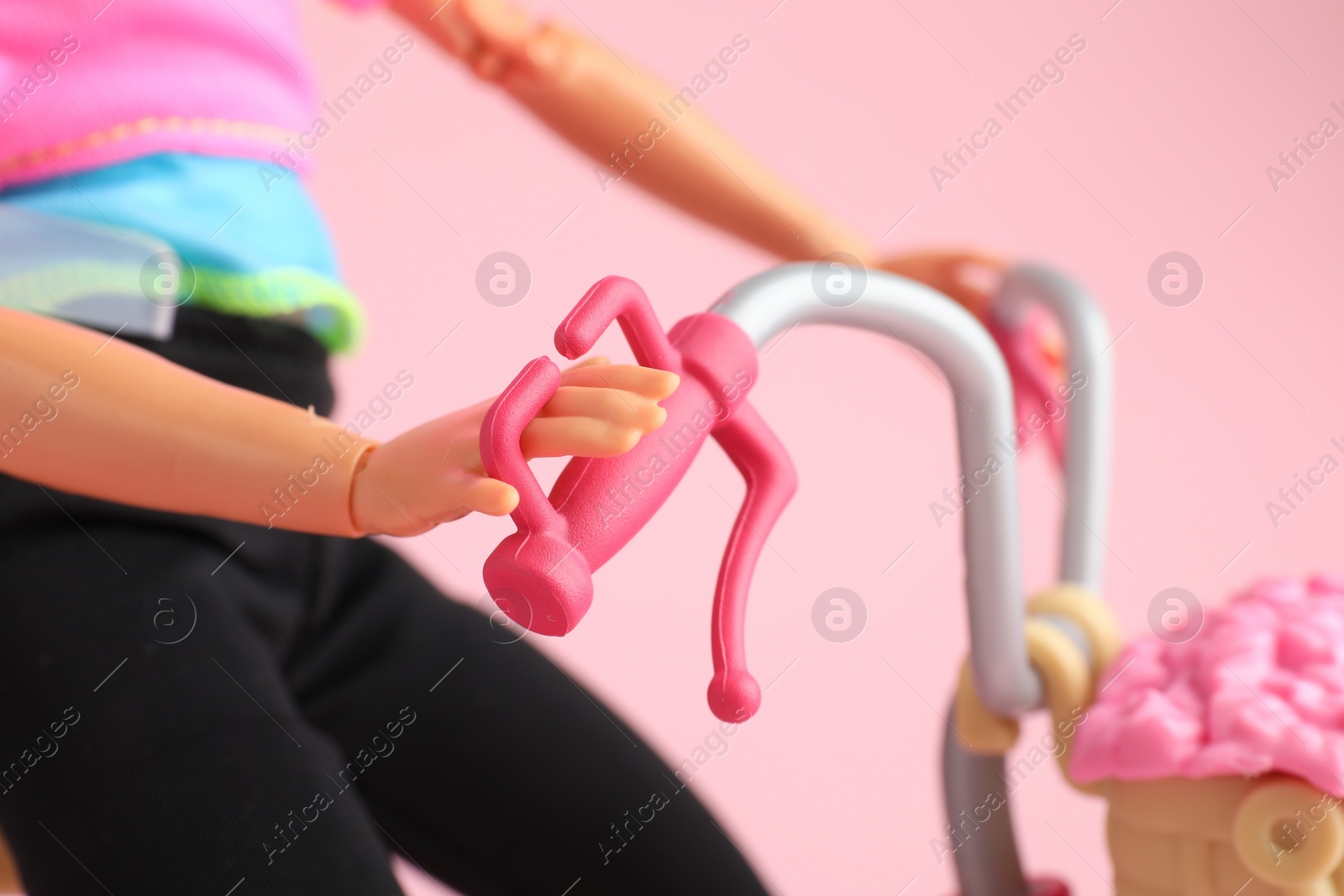 Photo of Mykolaiv, Ukraine - September 2, 2023: Barbie doll with bicycle on pink background, closeup