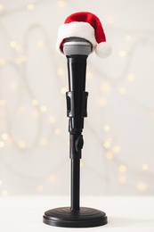 Microphone with Santa hat against blurred lights. Christmas music