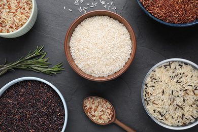 Photo of Flat lay composition with brown rice on black table