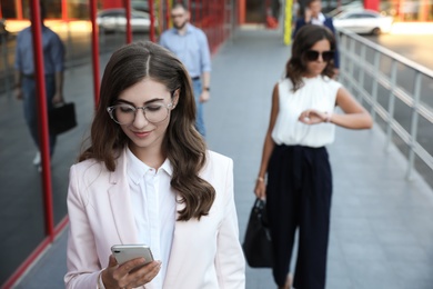 Young woman with smartphone on city street