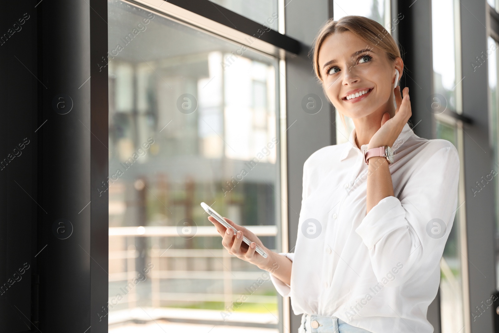 Photo of Portrait of female business trainer with smartphone indoors