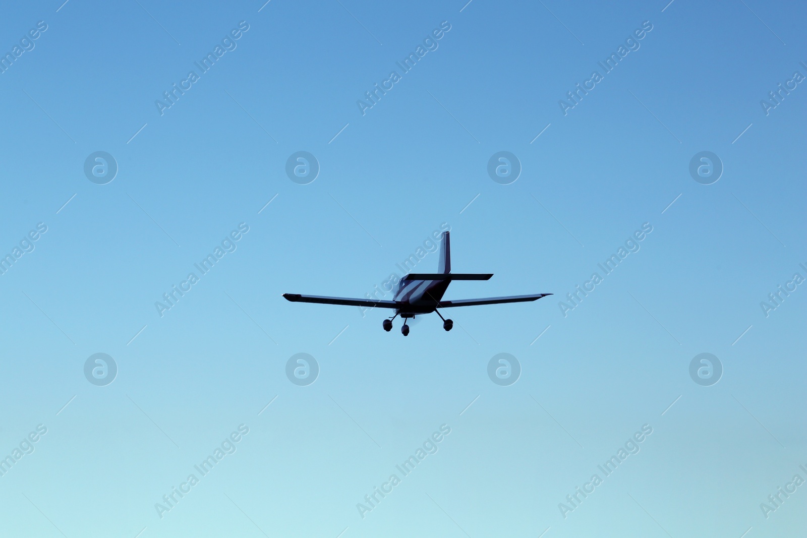 Photo of Modern ultralight airplane flying in blue sky