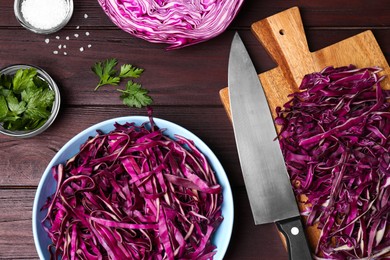 Photo of Fresh chopped red cabbage, salt and parsley on wooden table, flat lay