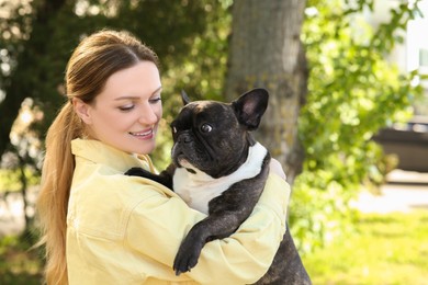 Photo of Happy woman with cute French Bulldog outdoors