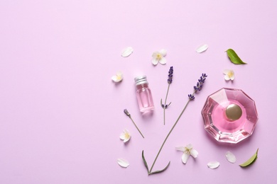 Photo of Flat lay composition with elegant perfume on lilac background, space for text