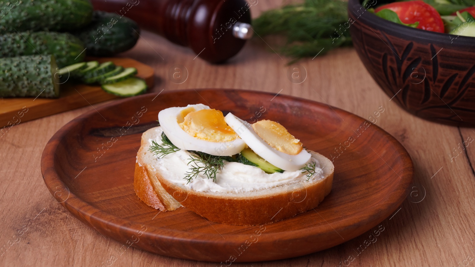 Photo of Tasty sandwich with boiled egg and cucumber on wooden table