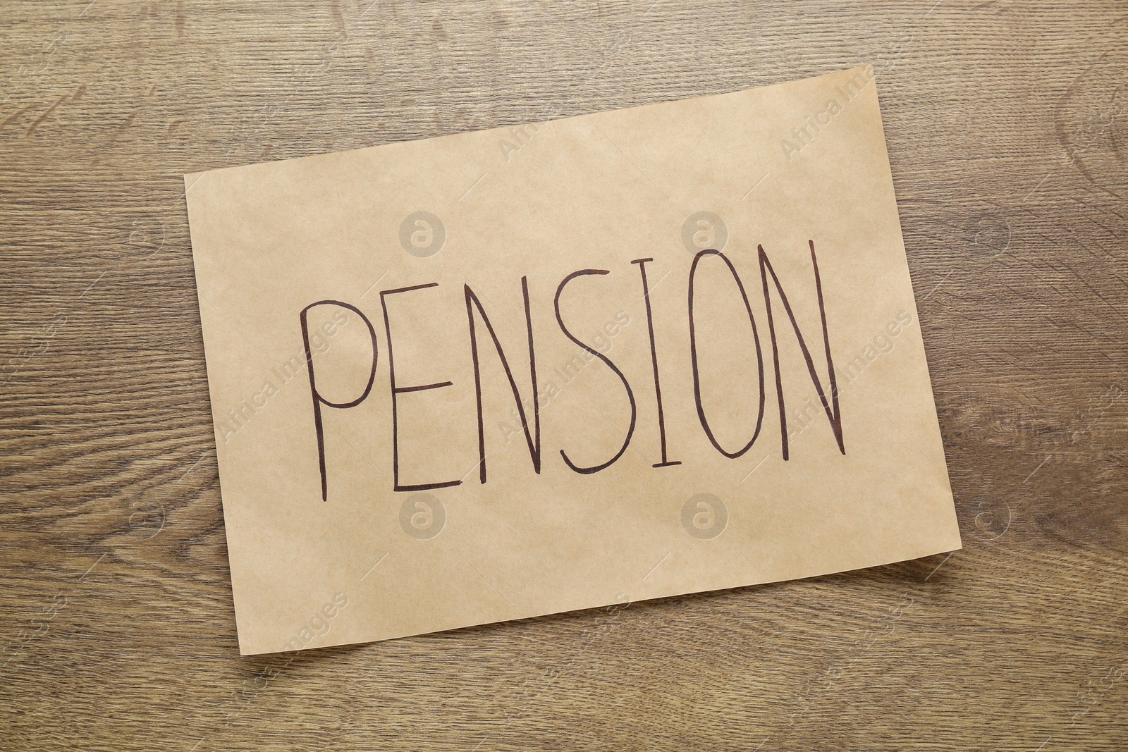 Photo of Card with word Pension on wooden table, top view