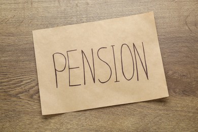 Photo of Card with word Pension on wooden table, top view