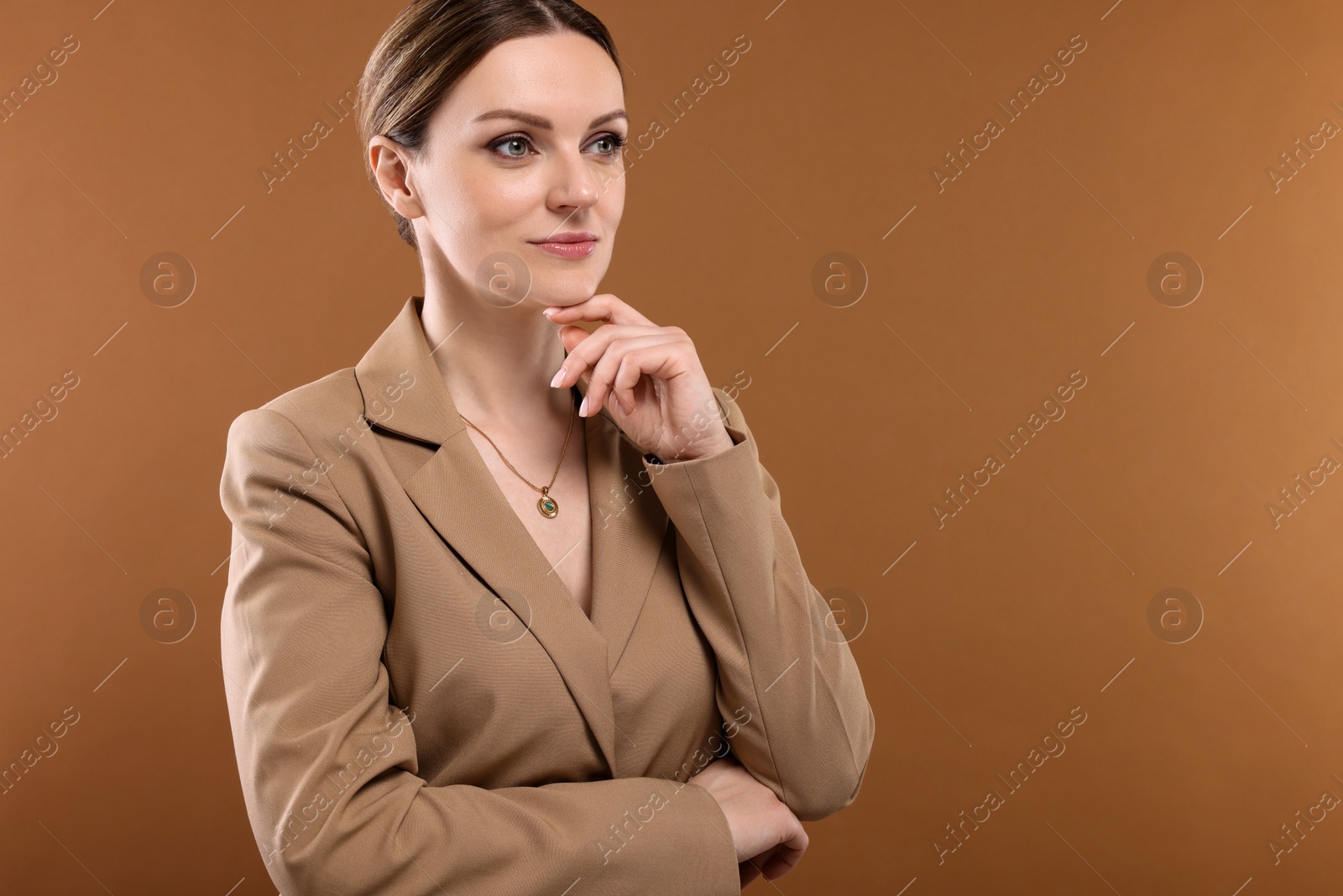 Photo of Beautiful woman with elegant necklace on brown background