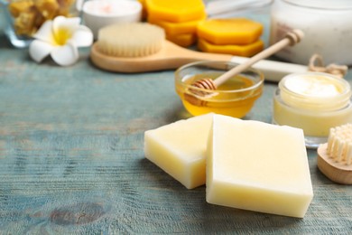 Natural beeswax on blue wooden table, closeup view. Space for text