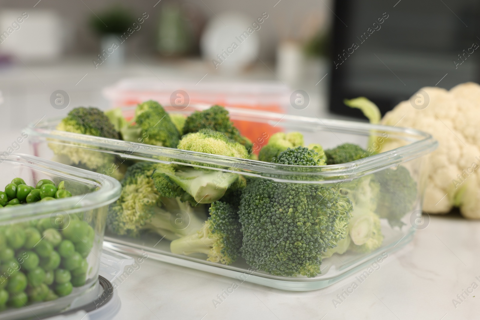 Photo of Containers with fresh products on white marble table, closeup. Food storage