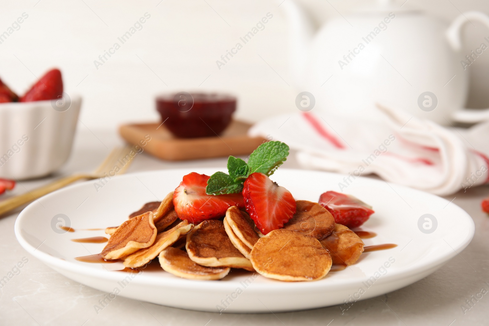 Photo of Cereal pancakes with strawberries on light grey marble table