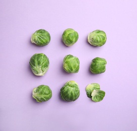 Photo of Fresh Brussels sprouts on violet background, flat lay