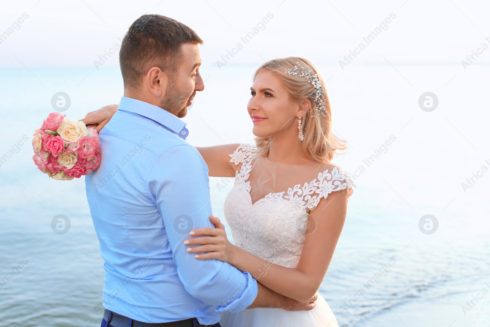 Photo of Wedding couple. Bride and groom hugging on beach