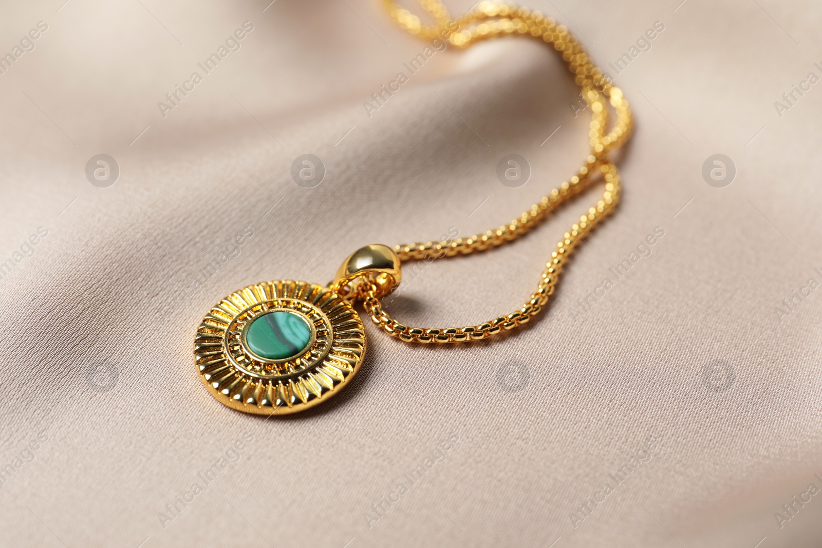 Photo of Elegant necklace on beige cloth, closeup. Stylish bijouterie