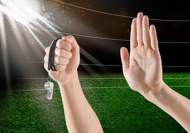 Image of Referee holding whistle and showing stop gesture at stadium, closeup
