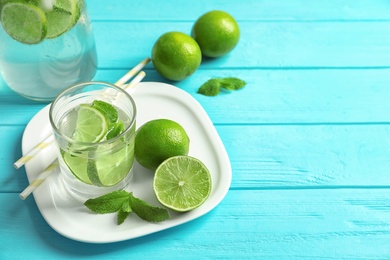 Natural lemonade with lime in glass on wooden table