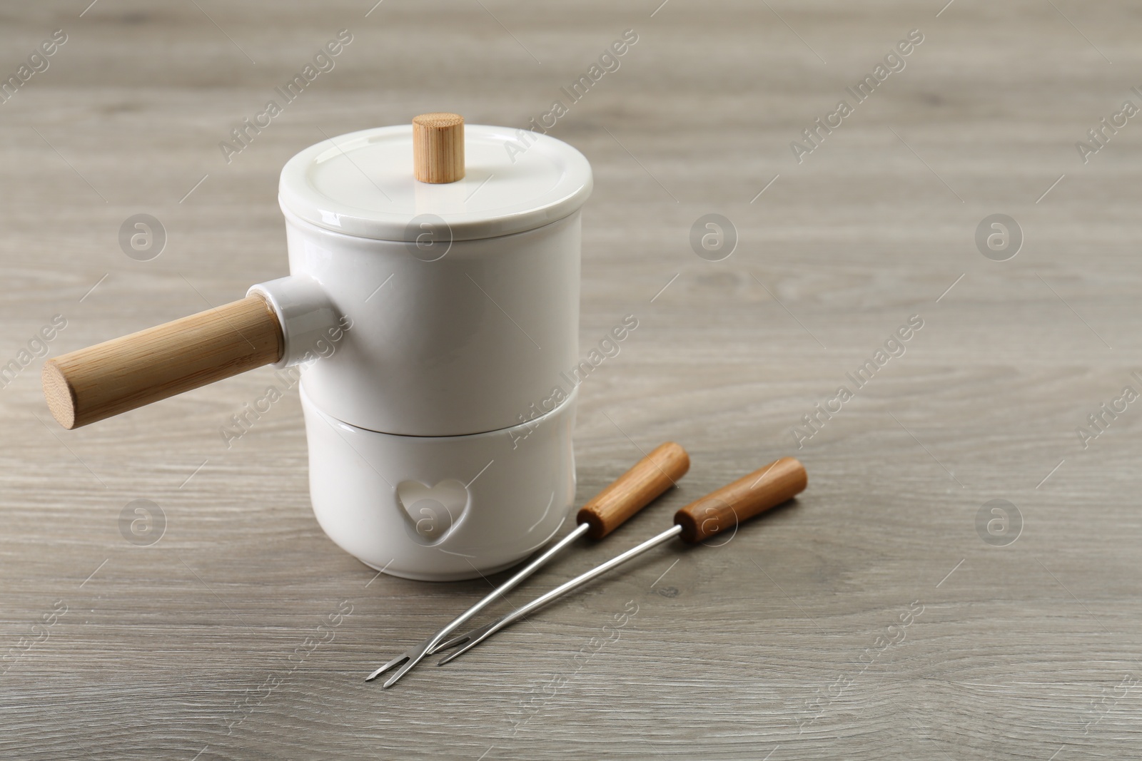 Photo of Fondue set on wooden table, space for text