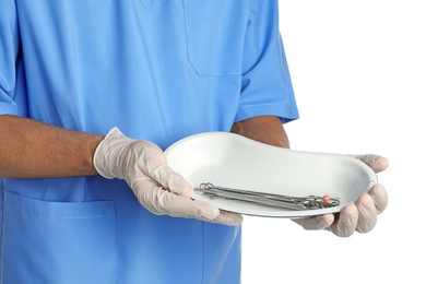 Photo of Male doctor holding dish with medical tools on white background, closeup. Medical objects