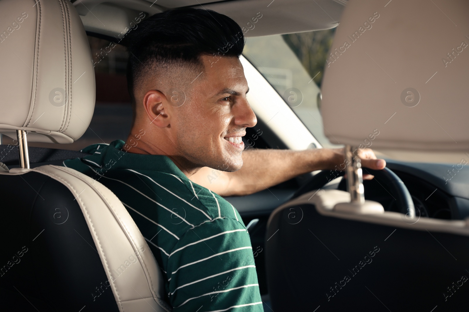 Photo of Handsome taxi driver sitting in modern car