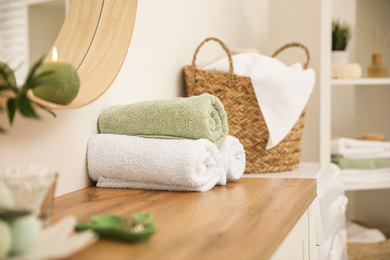 Fresh towels on wooden table in bathroom