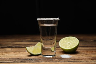 Photo of Mexican Tequila shot with salt and lime on wooden table