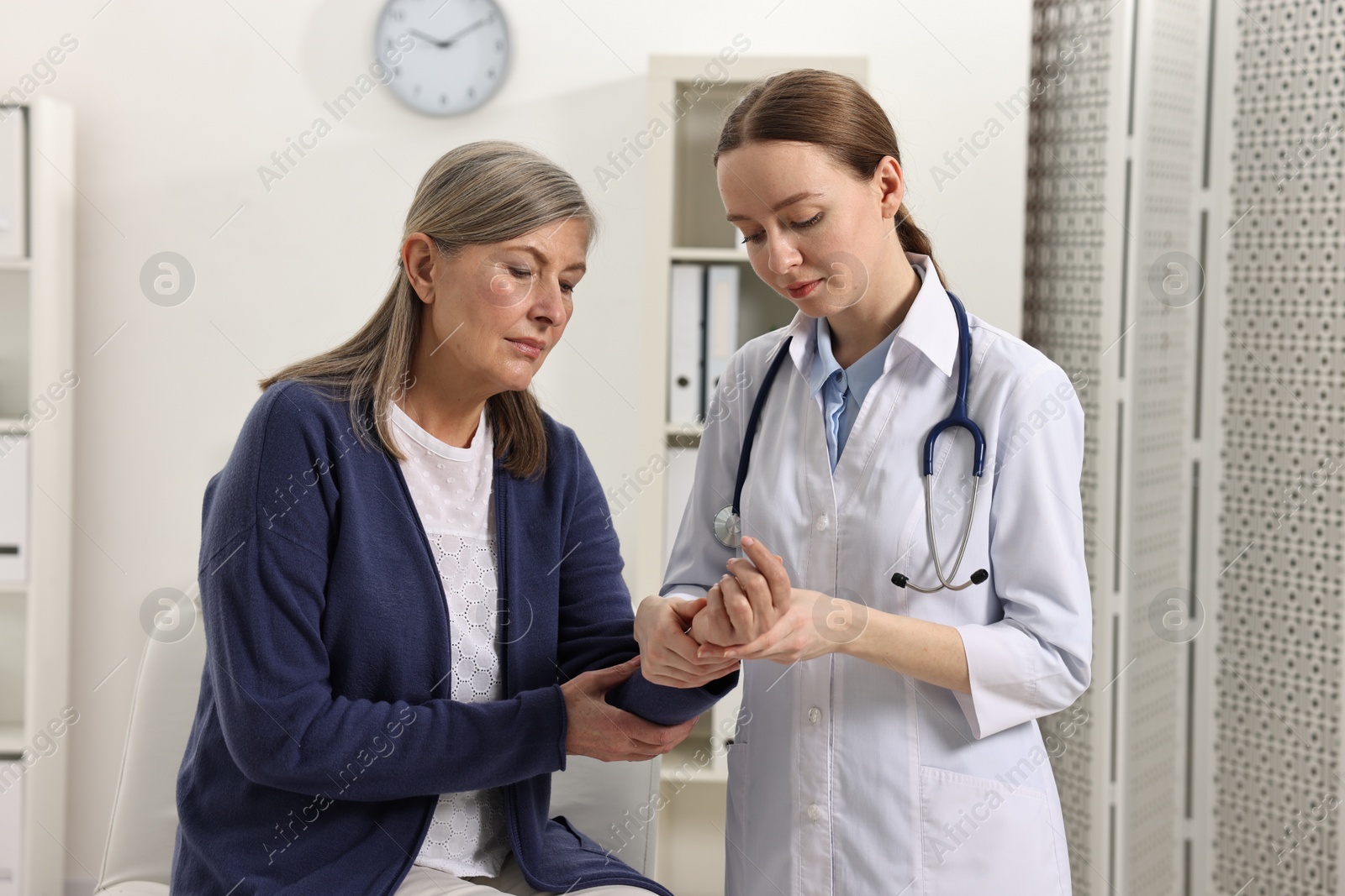 Photo of Arthritis symptoms. Doctor examining patient's wrist in hospital