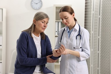 Photo of Arthritis symptoms. Doctor examining patient's wrist in hospital