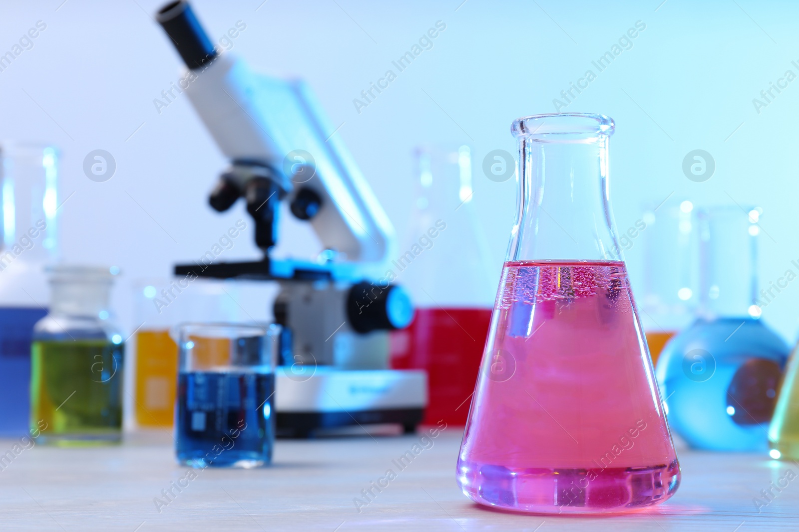 Photo of Conical flask with sample on table in chemistry laboratory, space for text