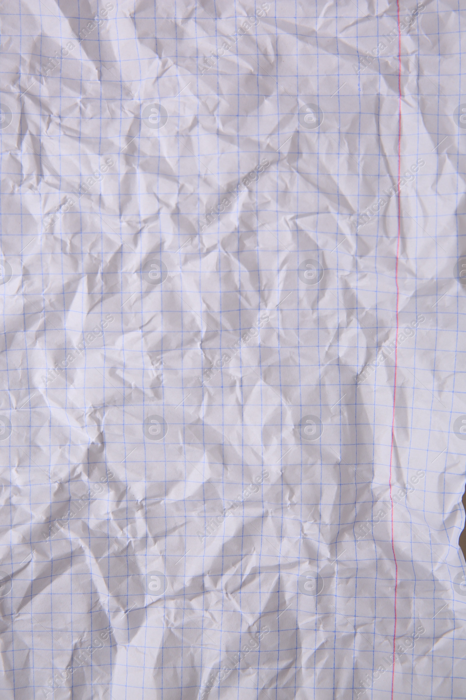 Photo of Sheet of crumpled checkered paper as background, top view