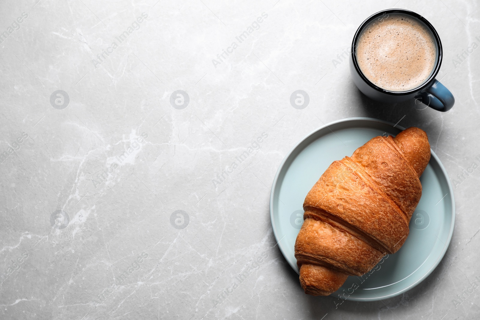 Photo of Fresh croissant and coffee on light grey marble table, flat lay. Space for text