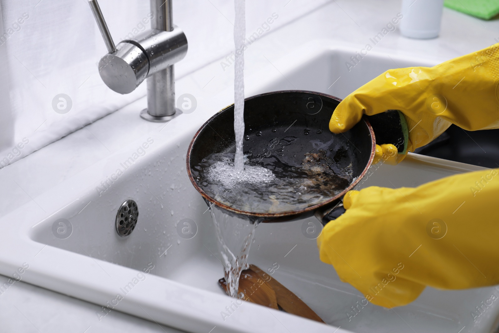 Photo of Woman washing dirty dishes in kitchen sink, closeup