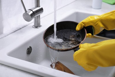 Woman washing dirty dishes in kitchen sink, closeup